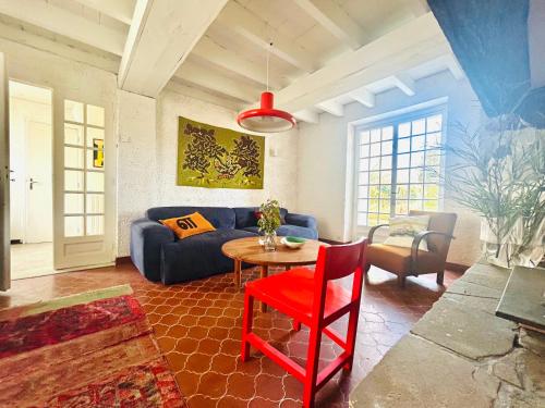 un salon avec un canapé bleu et une table dans l'établissement Maison de campagne Arty entièrement rénovée 4 chambres, à Roquecourbe