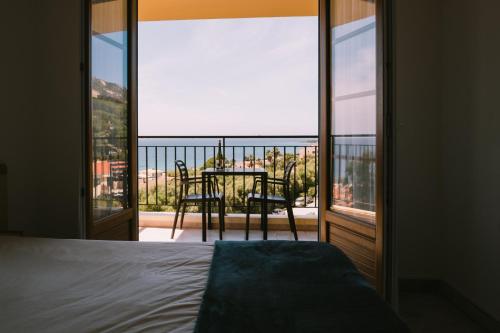 a bedroom with a bed and a view of a balcony at Creste E Mare in Ajaccio