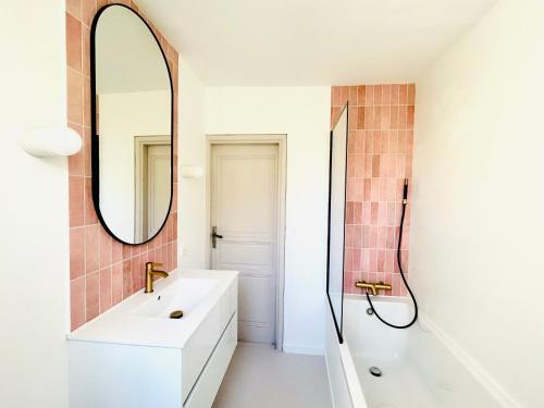 une salle de bain avec un lavabo et un miroir dans l'établissement Maison de campagne Arty entièrement rénovée 4 chambres, à Roquecourbe