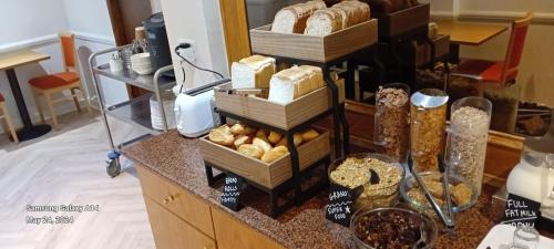 a counter with several baskets of bread and other food at Americana Hotel in London
