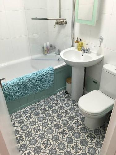 a bathroom with a sink and a tub and a toilet at Lovely 2- Bed Apartment in Hawick in Hawick