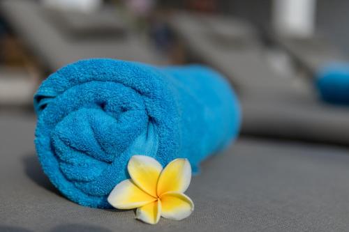 a blue towel with a frisbee and a flower at Olivia Estate by Villas Direct Bali in Seminyak