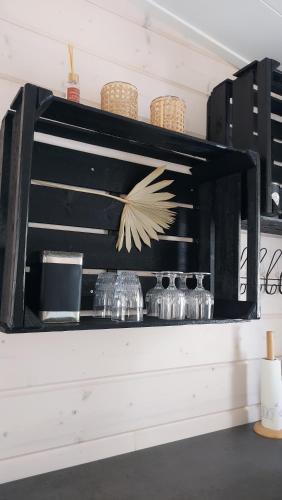 uno scaffale con bicchieri e ciotole su una parete di Glamping & Floating Sauna a Rejböle