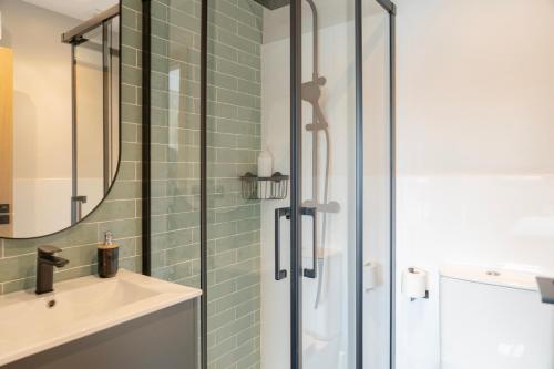 a bathroom with a glass shower and a sink at Apartamento Serea in Villanueva de Arosa