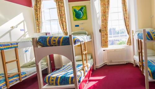a room with three bunk beds and a window at Castle Rock Hostel - Adults Only in Edinburgh