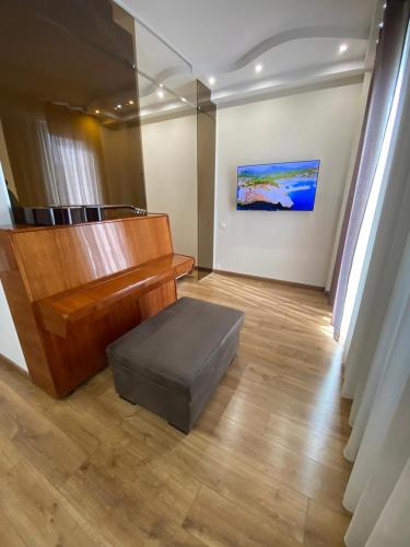 a room with a piano and a ottoman in a room at Apartment - "exclusive" in Tbilisi City