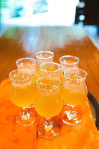 a group of glasses of orange juice on a wooden table at Daluyon Beach and Mountain Resort in Sabang