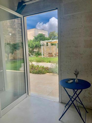 a blue table in front of a sliding glass door at Corte Mercurio B&B in Ugento