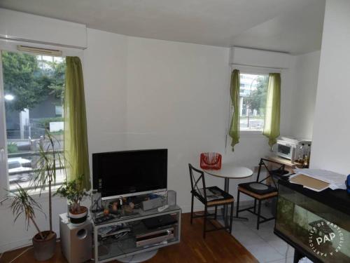 Il comprend un salon doté d'une télévision et d'une table avec des chaises. dans l'établissement Pret à usage & Commodat Chatillon Maison blanche - 30 nuitées minimum - Salarié mobilité ou étudiant stagiaire, à Châtillon