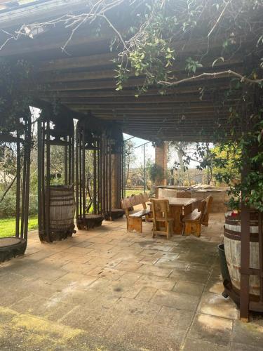 a patio with a table and chairs under a roof at Masseria Sotto le Stelle Provenzani in Casalabate