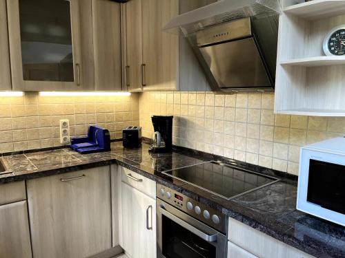 a kitchen with white cabinets and a stove top oven at Große Wohnung mit Billardtisch in Starnberg