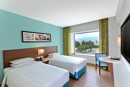 a hotel room with two beds and a television at Fairfield by Marriott Coimbatore in Coimbatore