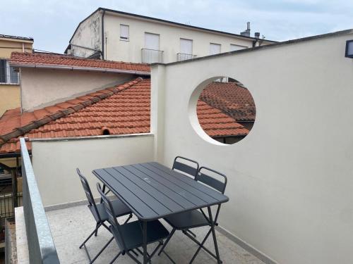 a table and chairs on a balcony with a window at Appartamento il Fortino in Forte dei Marmi