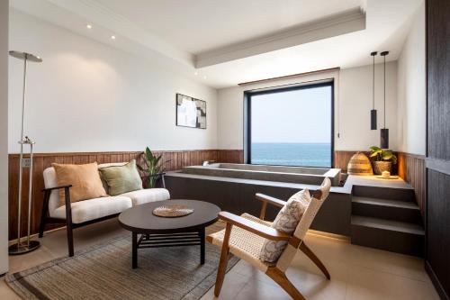 a living room with a tub and a table at Bale Resort in Boryeong