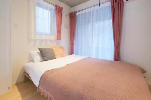 a bedroom with a large bed and a window at Frontier Comfort Kitaikebukuro by Tranova in Tokyo