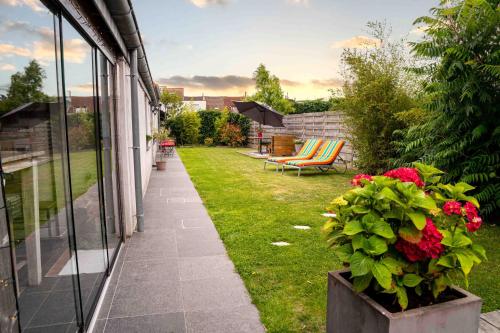 a garden with a patio with a bench and flowers at Oase 't Huyseke in Blankenberge