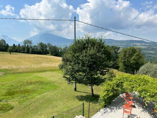 a view of a hill with a tree and a mountain at Fastuc B&B in Ponte nellʼAlpi