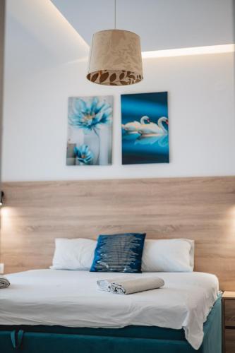 a bedroom with a bed with a wooden headboard at OLIVE GARDEN APARTMENT in Bar