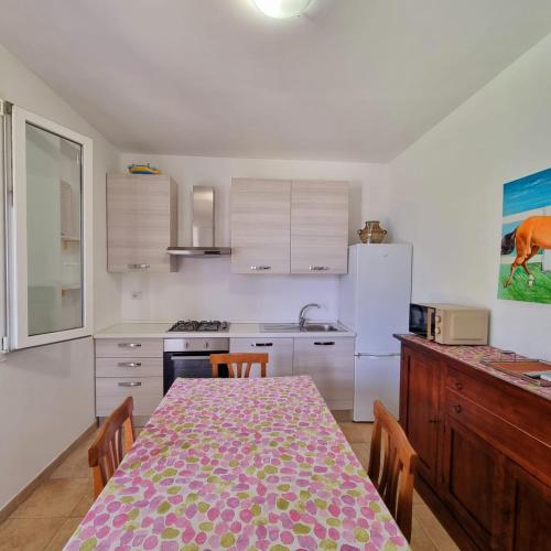 a kitchen with a table with chairs and a refrigerator at Villa Dei Lidi - HomeSalento com in Torre San Giovanni Ugento