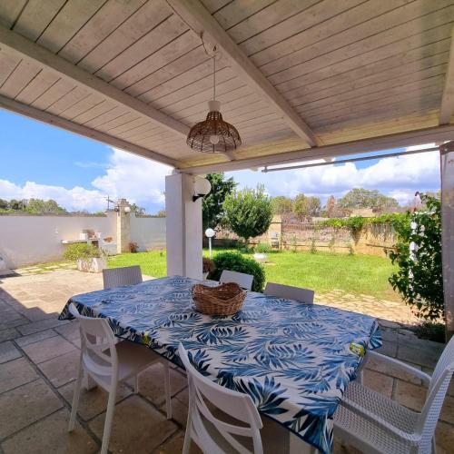 a table with a blue and white table cloth on a patio at Villa Dei Lidi - HomeSalento com in Torre San Giovanni Ugento