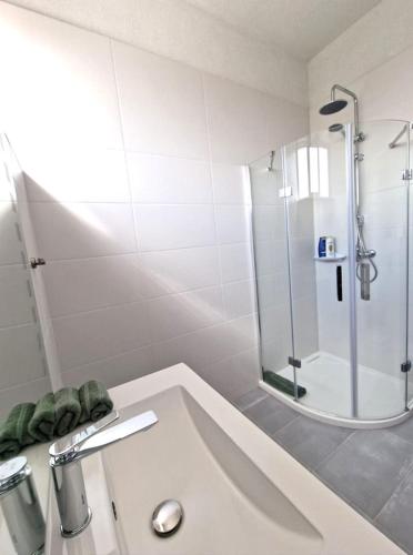 a white bathroom with a shower and a sink at BB Residence in Arad