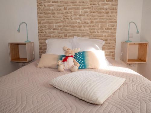 a teddy bear sitting on top of a bed at Les gites de Sylvie in Ussat