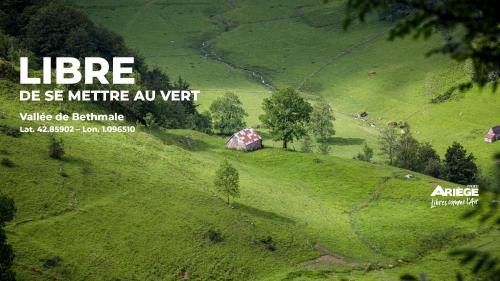 a green hill with a house on top of it at Les gites de Sylvie in Ussat