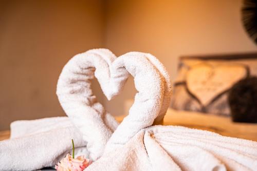 a towel shaped like a heart on a bed at Oase 't Huyseke in Blankenberge