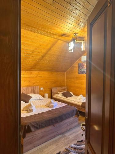 a room with two beds in a wooden cabin at Casa Favorit in Costeşti