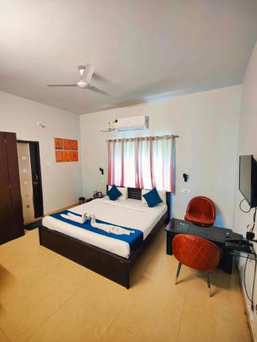 a bedroom with a bed and a desk and a television at 488, The Nook in Bhubaneshwar