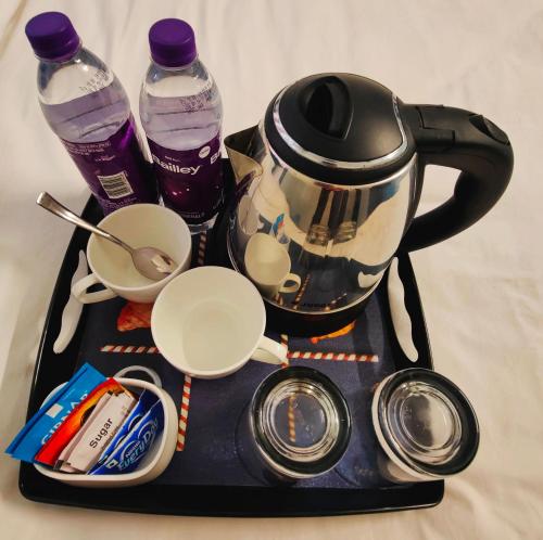 a tray with a tea kettle and two bottles of water at 488, The Nook in Bhubaneshwar