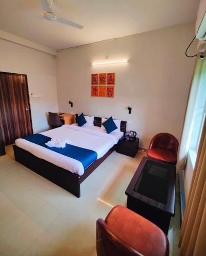 a bedroom with a large bed and a red chair at 488, The Nook in Bhubaneshwar