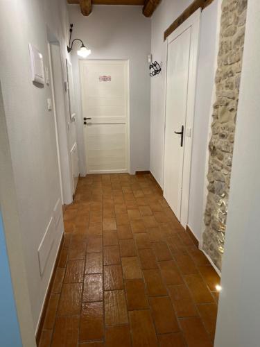 a hallway with a tile floor and a white door at B&B il gelsomino in Trarivi