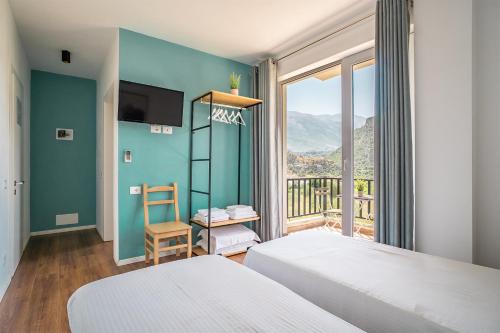 una camera da letto con due letti e una grande finestra di Guesthouse Lumo & pool a Përmet