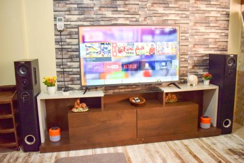 a flat screen tv sitting on a entertainment center at Casabella Apartment - Pristine Homes,Tom Mboya in Kisumu