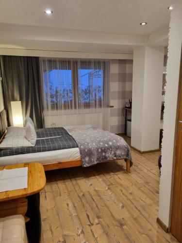 sypialnia z łóżkiem i oknem w obiekcie Apartament Granat w Zakopanem