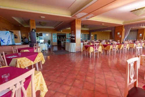 a restaurant with tables and chairs in a room at Hotel Villa Strassoldo "Ex Attianese Hotel Restaurant" in Cervignano del Friuli