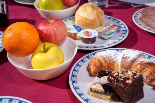 a table topped with plates of food with apples and bread at Hotel Villa Strassoldo "Ex Attianese Hotel Restaurant" in Cervignano del Friuli