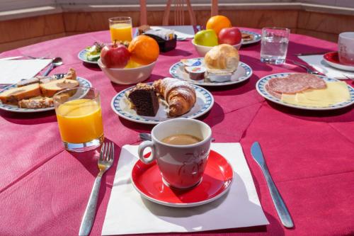 a table with breakfast foods and a cup of coffee at Hotel Villa Strassoldo "Ex Attianese Hotel Restaurant" in Cervignano del Friuli