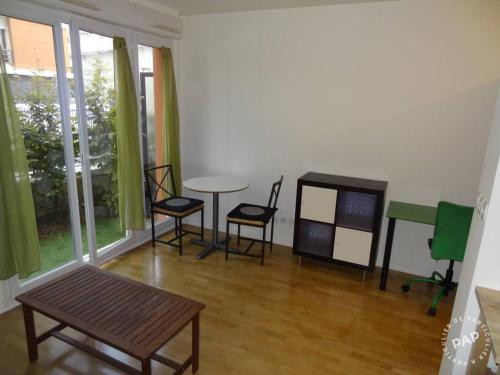 - un salon avec une table, des chaises et une télévision dans l'établissement Studio 23 m2 avec terrasse 16 m2 - Corporate housing ou bail civil travailleur mobilité Résidence standing Atlantis Plein Sud, à Massy