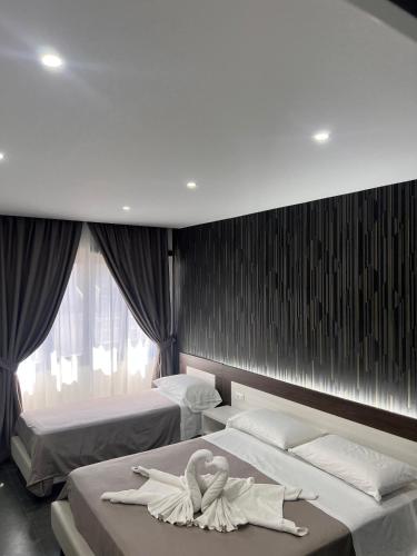 a room with two beds with swans on them at Hotel Blanc in Casoria