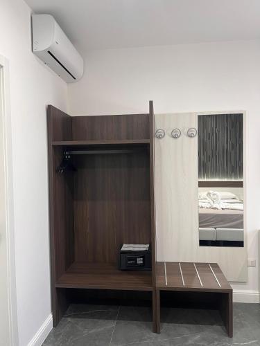 a room with a wooden book shelf and a mirror at Hotel Blanc in Casoria