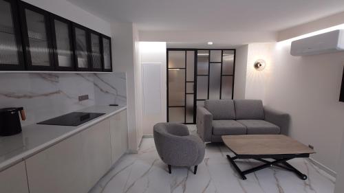 a living room with a chair and a table at Club Inn Appartement in Nice