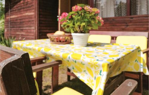 a yellow and white table with flowers on a patio at Holiday Home Morag Kretowiny V in Pojezierce