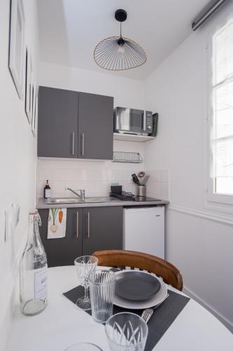 une cuisine avec une table avec une bouteille et une assiette dessus dans l'établissement Studio hyper centre au calme, à Caen