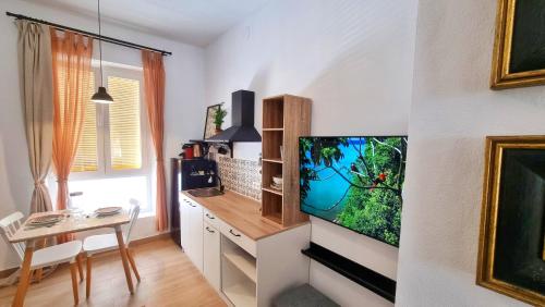 a living room with a flat screen tv on a wall at Rincón céntrico con encanto By Aloha Palma in Águilas