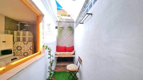 a small balcony with a table and a chair at Rincón céntrico con encanto By Aloha Palma in Águilas