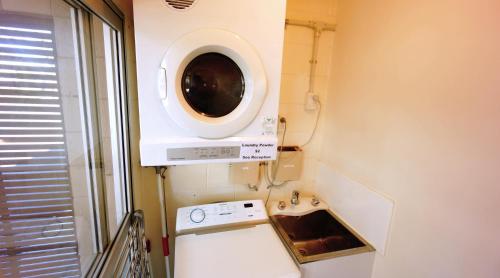 eine Küche mit einer Waschmaschine und einem Waschbecken in der Unterkunft Waihi Motel in Waihi