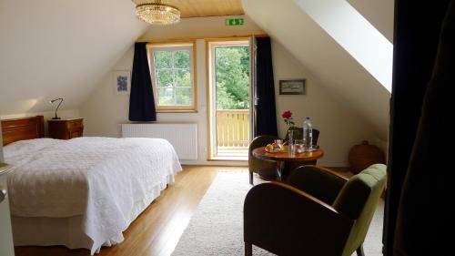 a bedroom with a bed and a table and chairs at Lilla Trulla Gårdshotell - Feels like home in Bolestad