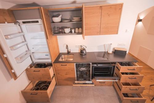 a small kitchen with wooden cabinets and a refrigerator at zumHofer in Gmund am Tegernsee